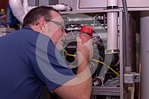 HVAC Technician  Looking Over A Gas Furnace