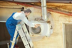 HVAC technician working on a capacitor part for condensing unit