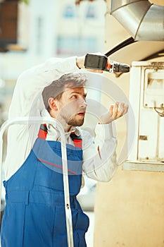 HVAC technician working on a capacitor part for condensing unit