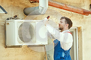 HVAC technician working on a capacitor part for condensing unit