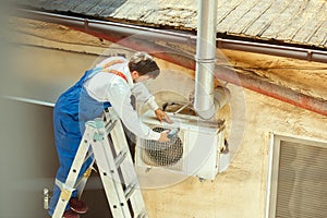 HVAC technician working on a capacitor part for condensing unit