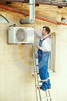 HVAC technician working on a capacitor part for condensing unit