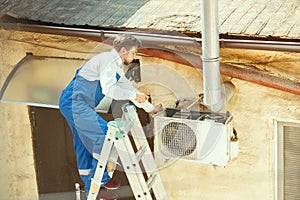 HVAC technician working on a capacitor part for condensing unit