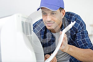 hvac technician working on capacitor part for condensing unit