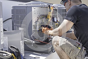 HVAC technician working on controls of air conditioner