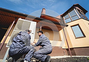 HVAC technicians servicing home heating and cooling system