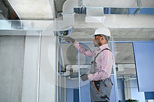 hvac african worker install ducted pipe system for ventilation and air conditioning. copy space