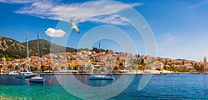 Hvar town with seagull`s flying over city, famous luxury travel destination in Croatia. Boats on Hvar island, one of the many