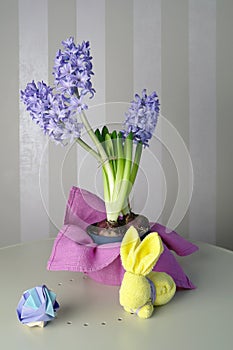 Hyacinths, easter bunny and origami in lilac and yellow colors, spring still life, selective focus