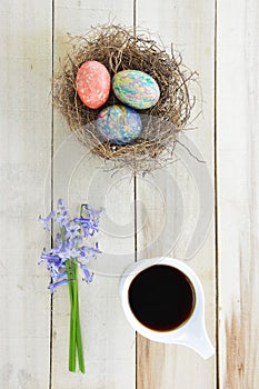 Hyacinths flowers,cup of black coffee and colored Easter eggs