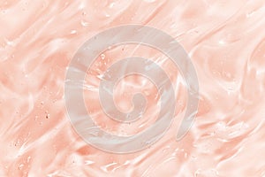 Hyaluronic acid serum texture. Skin care liquid gel background. Clear shiny pink beauty product with bubbles photo