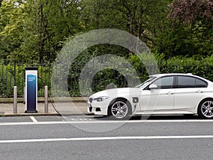 Hybrid electrical vehicle plugged into charging station in Dublin Ireland