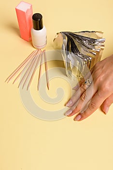 Hybrid manicure removal kit. The procedure for removing varnish from nails in progress