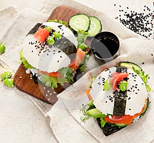 Hybrid modern food. Sushi burger with salmon, white rice, avocado, cucumber