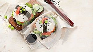 Hybrid modern food. Sushi burger with salmon, white rice, avocado, cucumber