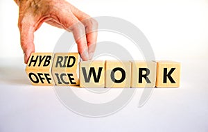 Hybrid or office work symbol. Businessman turns cubes and changes words `office work` to `hybrid work`. Beautiful white backgr