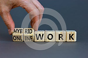 Hybrid or online work symbol. Businessman turns cubes and changes words `online work` to `hybrid work`. Beautiful grey backgro