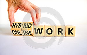 Hybrid or online work symbol. Businessman turns cubes and changes words `online work` to `hybrid work`. Beautiful white backgr