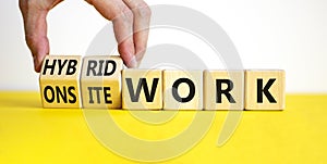 Hybrid or onsite work symbol. Businessman turns cubes and changes words `onsite work` to `hybrid work`. Beautiful white backgr