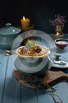 Hyderabadi chicken Biryani with raita served in a dish isolated on dark background side view of fastfood