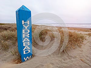 The Hydrabad shipwreck sign partially buried in sand