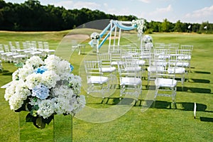 Hydrangea Flower Arrangements for Wedding. Blurred Rows of white chairs on green lawn before a wedding ceremony