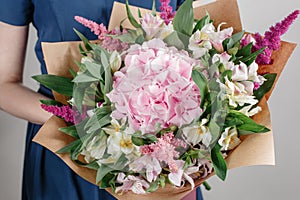 Hydrangea rich bouquet. Vintage floristic background, colorful roses, antique scissors and a rope on an old wooden table