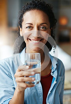 Hydrate to feel great. Portrait of a woman drinking a glass of water at home.