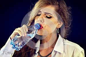 Hydration at Office. Sensitive teeth woman drinking cold bottle water