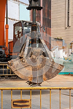 Hydraulic bucket excavator bucket excavator moving earth at excavation and restoration work on urban street with construction