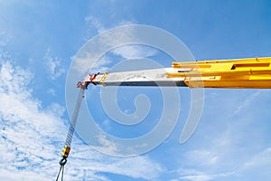 Hydraulic crane beams against blue sky