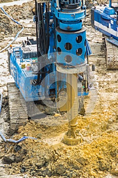 Hydraulic drilling machine is boring holes in the construction site for bored piles work. Bored piles are reinforced concrete elem