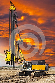 Hydraulic drilling machine at the construction site makes piles. Pile field. Modern drilling rig. Piles against the sunset. Work