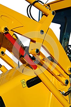 Hydraulic elements of the universal bulldozer of yellow color