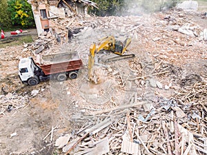 Hydraulic excavator and dump truck clearing out debris and garbage