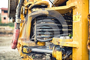 Hydraulic flexible pressure pipes and tubes. Close-up of industrial bulldozer with oil leaks