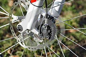 Hydraulic front disc brake on mountain bike with bicycle hub, caliper and spokes.