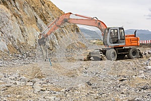 Hydraulic hammer grinding rock and stone at road construction works