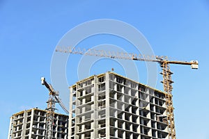 Hydraulic luffing jib tower cranes and workers being poured concrete into foundation.