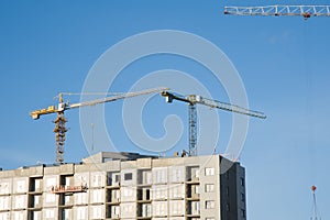 Hydraulic luffing jib tower cranes and workers being poured concrete into foundation.