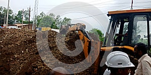 hydraulic machine digging soil around street area in India aug 2019