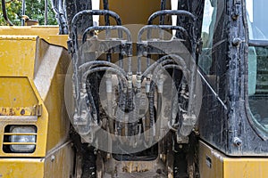 Hydraulic switchboard located in the front of the excavator, many hydraulic hoses visible.