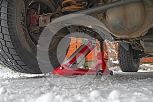 Hydraulic Trolley Jack Car Lift and Jack stand for changing car wheels. Snowy background