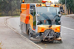 A hydraulically powered road sweeper sweeps the street