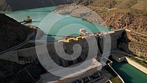 Hydroelectric dam on the river, water discharge from the reservoir, aerial view. Toktogul hydroelectric power station on