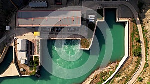 Hydroelectric dam on the river, water discharge from the reservoir, aerial view. Toktogul hydroelectric power station on