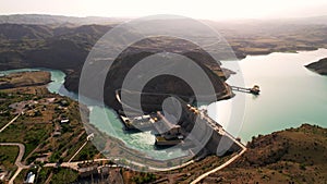 Hydroelectric dam on the river, water discharge from the reservoir, aerial view. Toktogul hydroelectric power station on