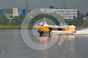 A hydrofoil boat goes along the river along the port city.