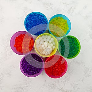 Hydrogel balls or Water beads in plastic cups, top view. Orbeez toy. Flexible gel balls for playing