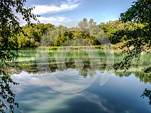 Hydrogen sulfide lake hydrogen sulfide lake landscape with turquoise water in tree branches framing.